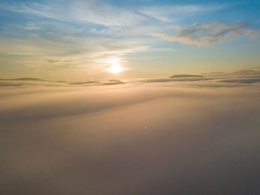 Ukrayna Karpatları 'nda sislerin üzerindeki şafak ışınları. Hava aracı görünümü.