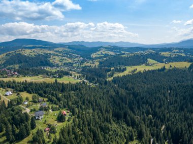 Yazın Ukrayna Karpatları 'nın yeşil dağları. Güneşli bir gün, nadir bulutlar. Hava aracı görünümü.