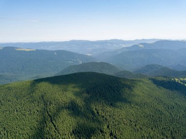 Bulutlu havada Ukrayna Karpatlarının yüksek dağları. Hava aracı görünümü.