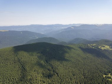 Bulutlu havada Ukrayna Karpatlarının yüksek dağları. Hava aracı görünümü.