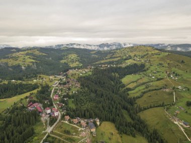 Yazın Ukrayna Karpat Dağları 'nın yeşil yamaçlarında. Bulutlu bir sabah, alçak bulutlar. Hava aracı görünümü.