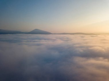 Ukrayna Karpatları 'nda sisin üstünde gün doğumu. Hava aracı görünümü.