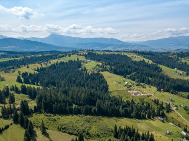 Yazın Ukrayna Karpatları 'nın yeşil dağları. Güneşli bir gün, nadir bulutlar. Hava aracı görünümü.