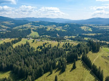 Yazın Ukrayna Karpatları 'nın yeşil dağları. Güneşli bir gün, nadir bulutlar. Hava aracı görünümü.