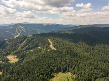 Yazın Ukrayna Karpatları 'nın yeşil dağları. Güneşli bir gün, nadir bulutlar. Hava aracı görünümü.