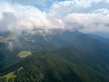 Yazın Ukrayna Karpatları 'nın yeşil dağları. Güneşli bir gün, nadir bulutlar. Hava aracı görünümü.