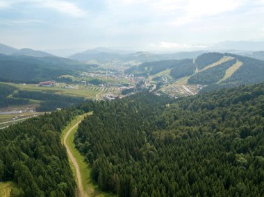 Yazın Ukrayna Karpatları 'nın yeşil dağları. Güneşli bir gün, nadir bulutlar. Hava aracı görünümü.