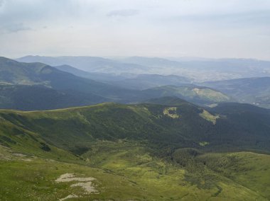 Bulutlu havada Ukrayna Karpatlarının yüksek dağları. Hava aracı görünümü.