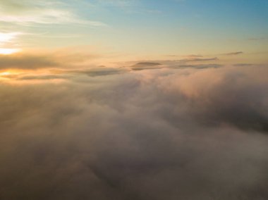 Ukrayna Karpatları 'nda sislerin üzerindeki şafak ışınları. Hava aracı görünümü.
