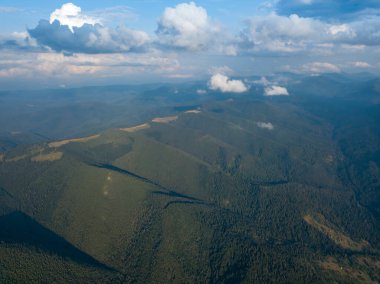 Yazın Ukrayna Karpat Dağları 'nın yeşil yamaçlarında. Bulutlu bir gün, alçak bulutlar. Hava aracı görünümü.