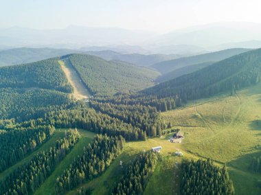 Yazın Ukrayna Karpatları 'nın yeşil dağları. Güneşli bir gün, nadir bulutlar. Hava aracı görünümü.