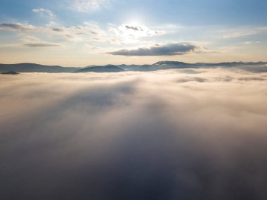 Ukrayna Karpatları 'nda yaz aylarında sislerin üzerinden uçarlar. Ufuktaki dağlar. Yoğun bir sis tabakası daimi bir halıyla dağları kaplar. Hava aracı görünümü.