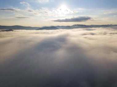 Ukrayna Karpatları 'nda yaz aylarında sislerin üzerinden uçarlar. Ufuktaki dağlar. Yoğun bir sis tabakası daimi bir halıyla dağları kaplar. Hava aracı görünümü.