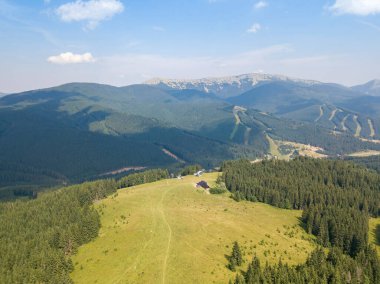 Yazın Ukrayna Karpatları 'nın yeşil dağları. Güneşli bir gün, nadir bulutlar. Hava aracı görünümü.