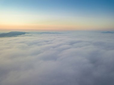 Ukrayna Karpatları 'nda sislerin üzerindeki şafak ışınları. Hava aracı görünümü.