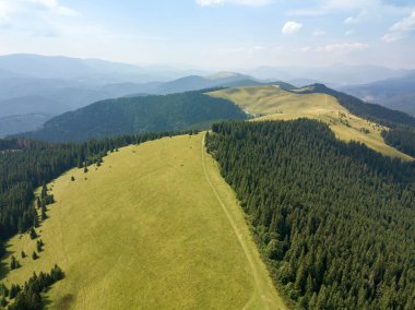 Yazın Ukrayna Karpatları 'nın yeşil dağları. Güneşli bir gün, nadir bulutlar. Hava aracı görünümü.