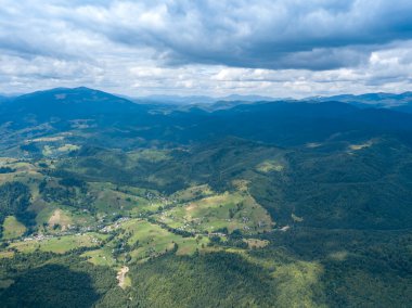 Yazın Ukrayna Karpatları 'nın yeşil dağları. Yamaçlarda kozalaklı ağaçlar. Hava aracı görünümü.