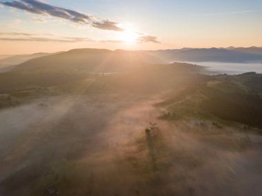 Ukrayna Karpatları 'nda sisin üstünde gün doğumu. Hava aracı görünümü.