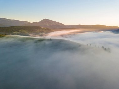 Ukrayna Karpatları 'nda sisin üstünde gün doğumu. Hava aracı görünümü.