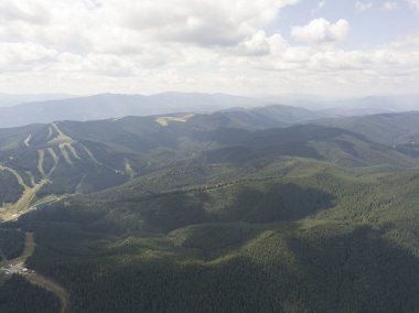 Yazın Ukrayna Karpatları 'nın yeşil dağları. Güneşli bir gün, nadir bulutlar. Hava aracı görünümü.