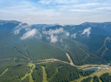 Yazın Ukrayna Karpatları 'nın yeşil dağları. Güneşli bir gün, nadir bulutlar. Hava aracı görünümü.