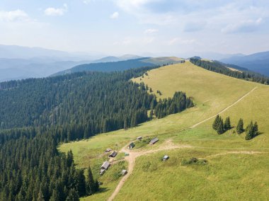 Yazın Ukrayna Karpatları 'nın yeşil dağları. Güneşli bir gün, nadir bulutlar. Hava aracı görünümü.