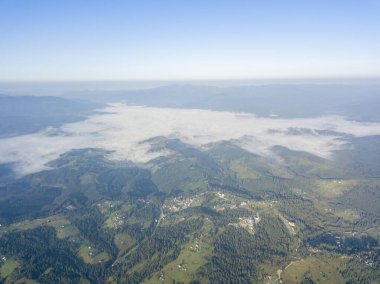Ukrayna Karpatlarının dağlarında yüksek uçuş. Vadide sis var. Hava aracı görünümü.