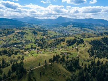 Yazın Ukrayna Karpatları 'nın yeşil dağları. Yamaçlarda kozalaklı ağaçlar. Hava aracı görünümü.