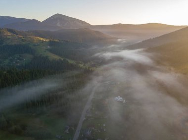Ukrayna Karpatları 'nda sisin üstünde gün doğumu. Hava aracı görünümü.