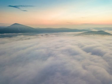 Ukrayna Karpatları 'nda sislerin üzerindeki şafak ışınları. Hava aracı görünümü.