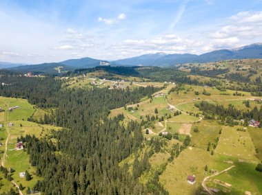 Yazın Ukrayna Karpatları 'nın yeşil dağları. Güneşli bir gün, nadir bulutlar. Hava aracı görünümü.