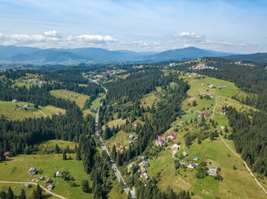 Yazın Ukrayna Karpatları 'nın yeşil dağları. Güneşli bir gün, nadir bulutlar. Hava aracı görünümü.
