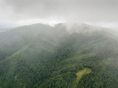 Ukrayna Karpatlarının yeşil dağları bulutların üzerinde dinleniyor. Hava aracı görünümü.
