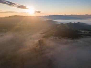 Ukrayna Karpatları 'nda sisin üstünde gün doğumu. Hava aracı görünümü.