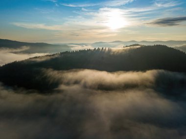 Sisli Karpatlar 'da güneşli bir sabah. Dağları ince bir sis tabakası kaplıyor. Hava aracı görünümü.