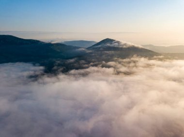 Ukrayna Karpatları 'nda yaz aylarında sislerin üzerinden uçarlar. Ufuktaki dağlar. Hava aracı görünümü.