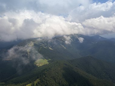 Yazın Ukrayna Karpatları 'nın yeşil dağları. Güneşli bir gün, nadir bulutlar. Hava aracı görünümü.