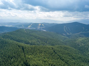 Yazın Ukrayna Karpatları 'nın yeşil dağları. Güneşli bir gün, nadir bulutlar. Hava aracı görünümü.