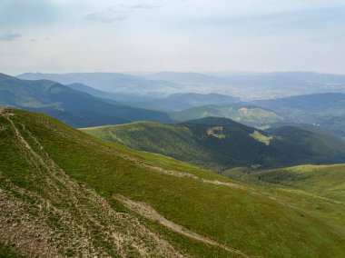 Bulutlu havada Ukrayna Karpatlarının yüksek dağları. Hava aracı görünümü.