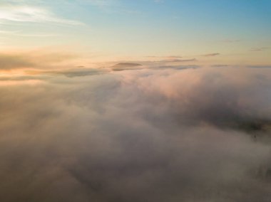 Ukrayna Karpatları 'nda sislerin üzerindeki şafak ışınları. Hava aracı görünümü.