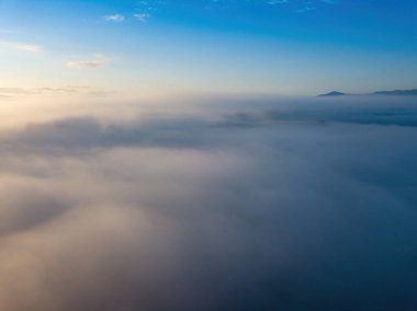 Ukrayna Karpatları 'nda sislerin üzerindeki şafak ışınları. Hava aracı görünümü.