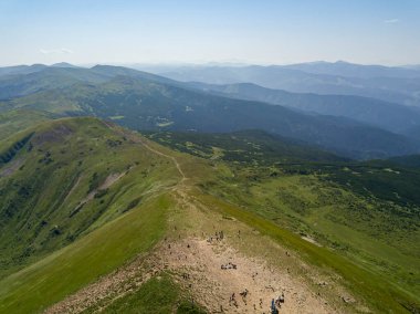 Bulutlu havada Ukrayna Karpatlarının yüksek dağları. Hava aracı görünümü.