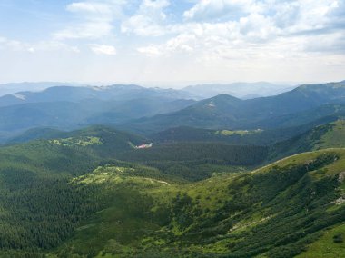 Bulutlu havada Ukrayna Karpatlarının yüksek dağları. Hava aracı görünümü.