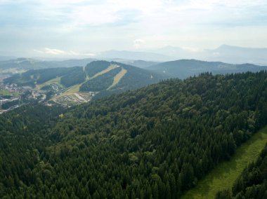 Yazın Ukrayna Karpatları 'nın yeşil dağları. Güneşli bir gün, nadir bulutlar. Hava aracı görünümü.