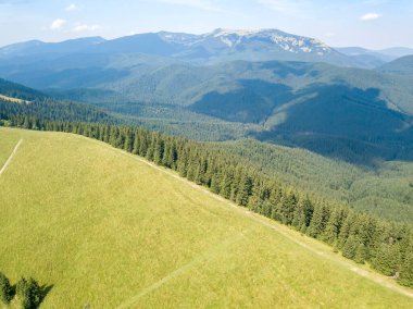 Yazın Ukrayna Karpatları 'nın yeşil dağları. Güneşli bir gün, nadir bulutlar. Hava aracı görünümü.