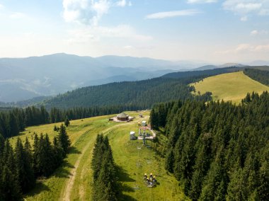 Yazın Ukrayna Karpatları 'nın yeşil dağları. Güneşli bir gün, nadir bulutlar. Hava aracı görünümü.