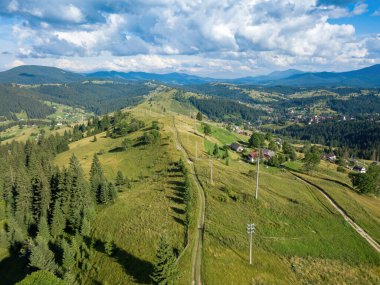 Yazın Ukrayna Karpatları 'nın yeşil dağları. Güneşli bir gün, nadir bulutlar. Hava aracı görünümü.