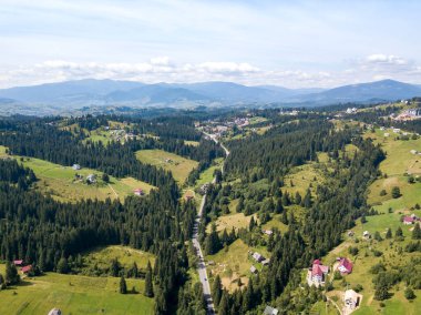 Yazın Ukrayna Karpatları 'nın yeşil dağları. Güneşli bir gün, nadir bulutlar. Hava aracı görünümü.