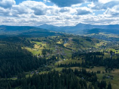 Yazın Ukrayna Karpatları 'nın yeşil dağları. Yamaçlarda kozalaklı ağaçlar. Hava aracı görünümü.