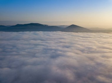Ukrayna Karpatları 'nda yaz aylarında sislerin üzerinden uçarlar. Ufuktaki dağlar. Hava aracı görünümü.